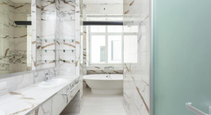 A stylish bathroom featuring a marble design and contemporary bathtub, ideal for luxury interiors.