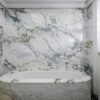 Luxurious modern bathroom with marble tub and wall, featuring elegant design elements.