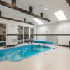 Modern indoor pool area featuring bright lighting and comfortable seating.