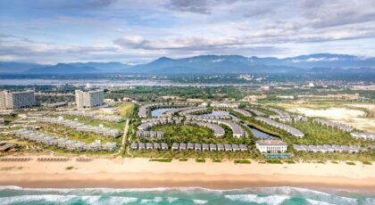 Stunning aerial view of a beachside resort with palm trees and modern architecture.