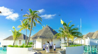 A family enjoys a sunny day at a luxurious overwater resort in a tropical paradise.