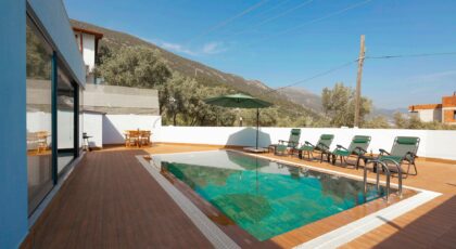 Relax at a luxurious villa with mountain-view pool and sun loungers.