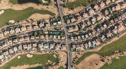 Aerial shot of luxury villas and golf course in Sheikh Zayed, Cairo, showcasing modern architecture and lush greenery.