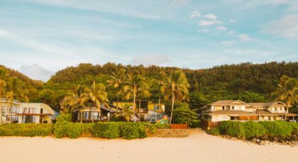 Beautiful beachfront villas with palm trees on a sandy coastline. Ideal tropical getaway.