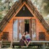 A couple enjoying the tropical view from their rustic wooden bungalow in Sri Lanka.