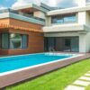 A stunning modern house with a spacious pool and green garden, ideal for relaxation.