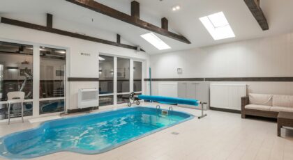 Modern indoor pool area featuring bright lighting and comfortable seating.