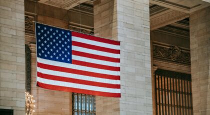 American flag hangs in a grand interior, symbolizing patriotism within an architectural landmark.