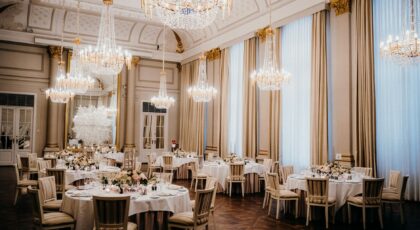 Luxurious ballroom featuring elegant chandeliers and a sophisticated dining arrangement, ideal for events.