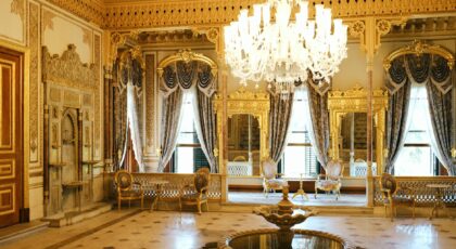 Lavishly decorated palace room with gold accents and elegant chandeliers in Istanbul, Turkey.