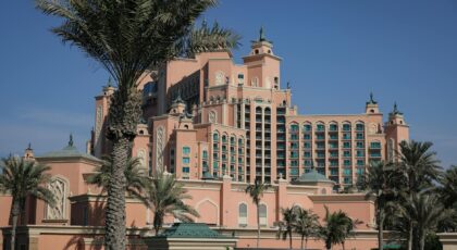 Stunning architectural design of Atlantis Hotel in Dubai with palm trees framing the scene.