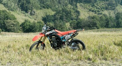 A motocross bike in a serene meadow in East Java, Indonesia, ready for adventure.