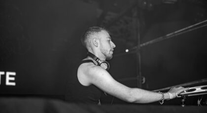 Black and white image of a DJ performing live, capturing the focus and energy of the performance.