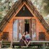 A couple enjoying the tropical view from their rustic wooden bungalow in Sri Lanka.