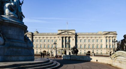 Stunning view of Buckingham Palace with clear blue skies and iconic statues in London, England.
