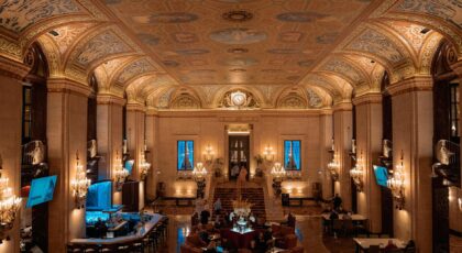 Luxurious hotel lobby with ornate ceiling and elegant chandeliers.