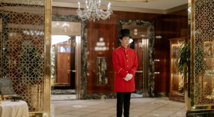 Elegant hotel lobby showcasing a uniformed doorman ready to welcome guests.