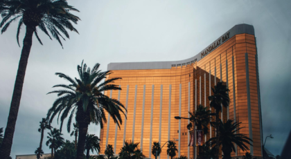 Golden facade of Mandalay Bay Resort amidst palm trees in Las Vegas, Nevada.