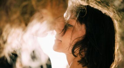 A romantic moment captured between a couple sharing a tender embrace, glowing in sunlight.