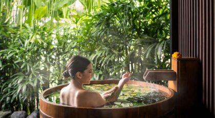 A woman enjoys a serene spa bath surrounded by lush greenery in Ubud, Bali.